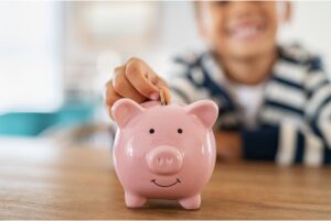 Child saving money in piggybank