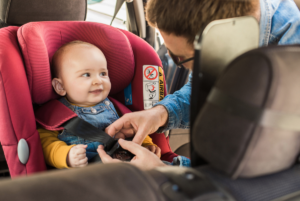 Dad buckling baby into car