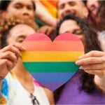 Group of LGBTQ youth holding rainbow heart
