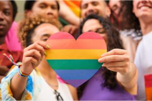 Group of LGBTQ youth holding rainbow heart