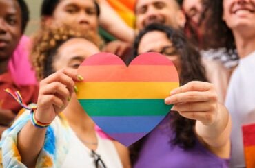 Group of LGBTQ youth holding rainbow heart
