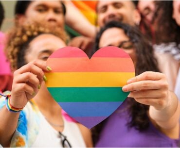 Group of LGBTQ youth holding rainbow heart