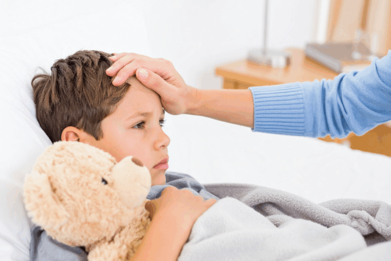 Have a sick kid at home? Here are 5 hacks to help you prepare for a vomiting child Mom comforting a sick child