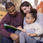 Mixed race family reading a book