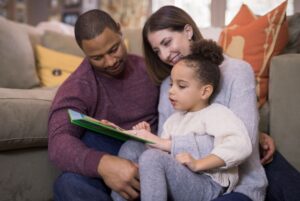 Mixed race family reading a book