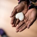 Hands holding a heart shaped stone