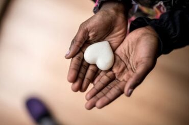 No one was helping Black transgender youth. So these parents stepped in. Hands holding a heart shaped stone