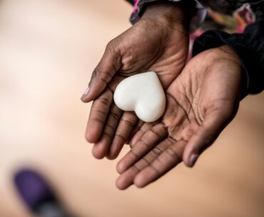 Hands holding a heart shaped stone