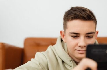 Character AI just became the first major AI chatbot platform to go 18+ Teen boy engrossed in smartphone