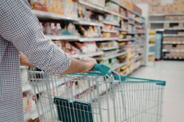 Pushing grocery cart down aisle