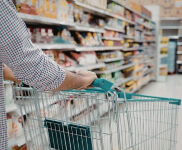 Pushing grocery cart down aisle