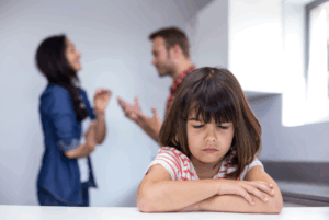 Sad child listening to parents argue