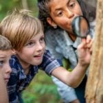 Kids exploring nature with magnifying glass