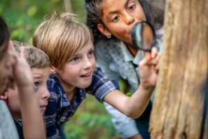 Kids exploring nature with magnifying glass
