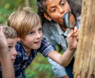 Kids exploring nature with magnifying glass