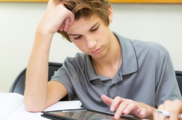Teen student uses a tablet device in the classroom