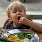 Toddler eating vegetables