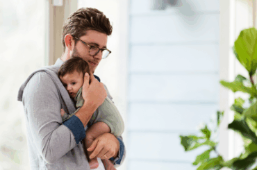 New research reveals the mental health challenges of first-time fathers Dad holding newborn baby