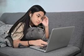 Teen playing game on laptop