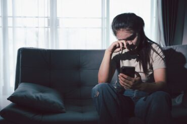 Sad teen sitting on couch