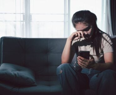 Sad teen sitting on couch