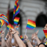 Crowd waving rainbow pride flags