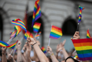 Crowd waving rainbow pride flags