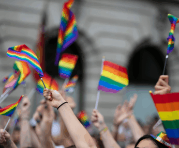 Crowd waving rainbow pride flags