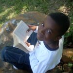 Boy reading book and smiling