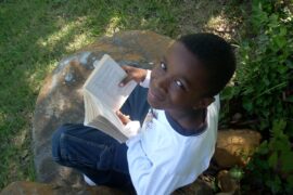 Boy reading book and smiling