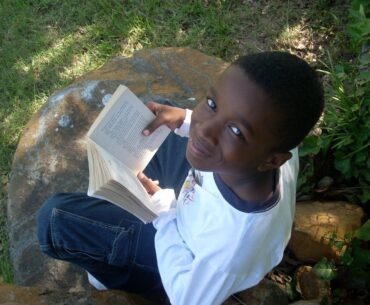 Boy reading book and smiling