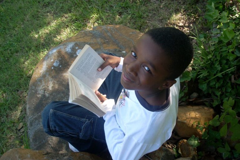 When she didn’t grow up seeing herself in books, she became the librarian she never had Boy reading book and smiling