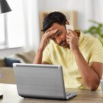 Stressed person on phone and laptop