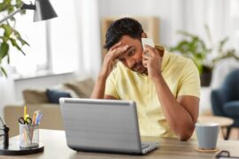 Stressed person on phone and laptop