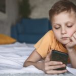 Kid staring at smartphone