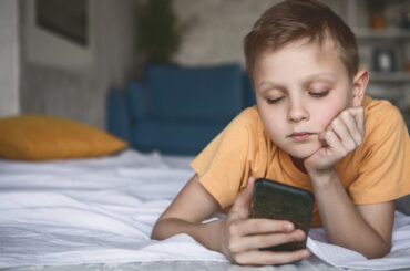 What parents need to know about AI and healthy child development, by age Kid staring at smartphone