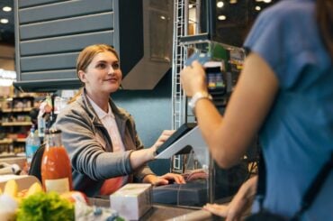 17 states and localities just raised their minimum wage, but the federal rate remains stagnant Cashier working at food store