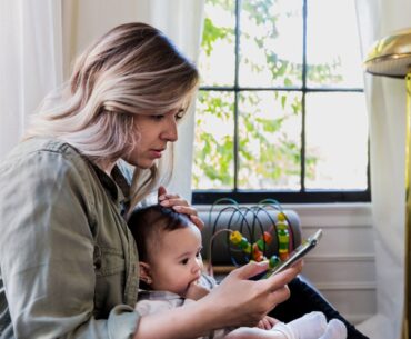 Worried mom consulting phone for answers