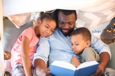 Black dad reading to kids
