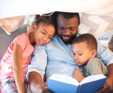 Black dad reading to kids