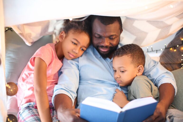 Black dad reading to kids