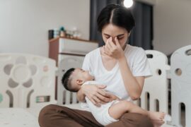 Tired stressed mom holding sleeping baby