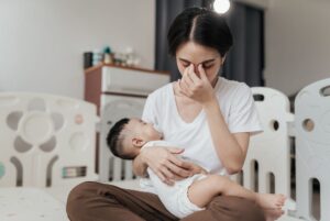 Tired stressed mom holding sleeping baby