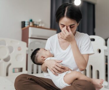 Tired stressed mom holding sleeping baby
