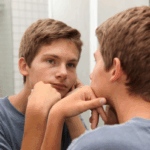 Teen boy looking in mirror