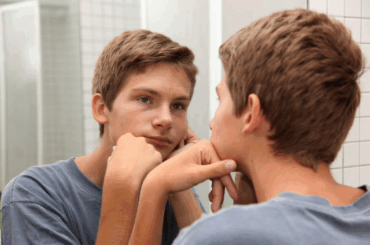 Teen boy looking in mirror
