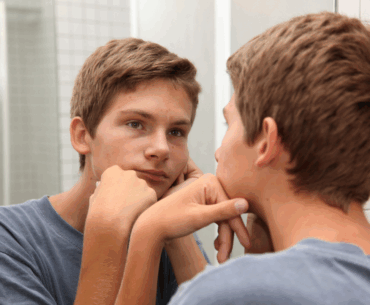 Teen boy looking in mirror