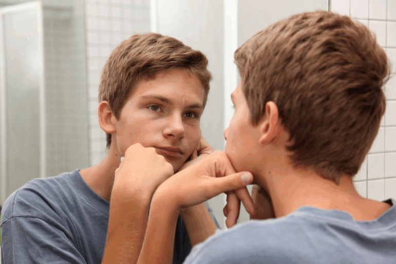 Teen boy looking in mirror