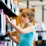Kid browsing library shelves