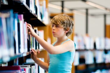 20 classic and modern-classic children’s books that have been banned or challenged Kid browsing library shelves